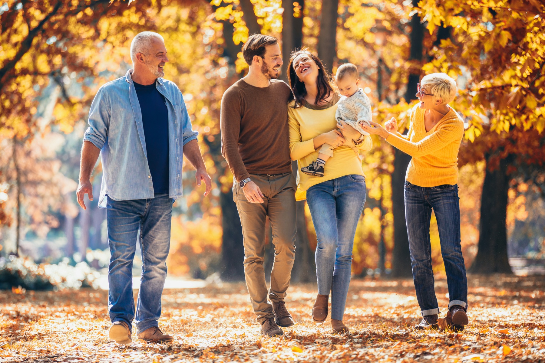 Familie über drei Generationen bei einem Spaziergang im Herbst